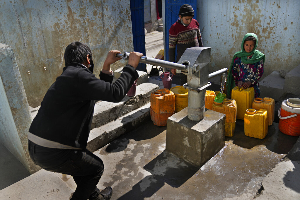 Afghans fill containers with water from a well at a mosque in Kabul, Afghanistan, Sunday, Feb. 20, 2022. (AP Photo/Hussein Malla)