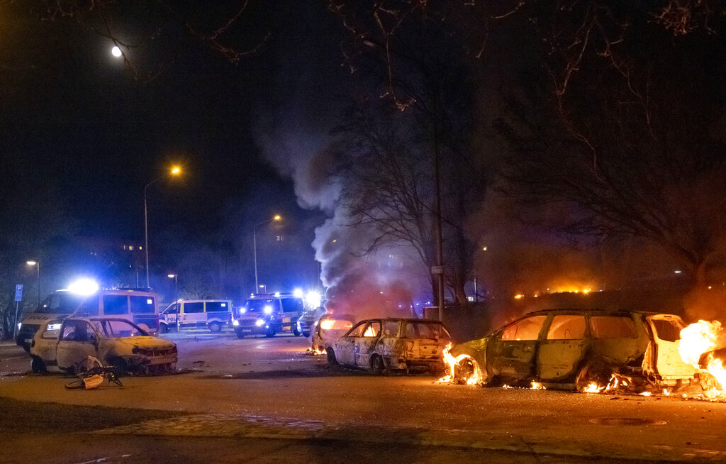 Cars are engulfed by flames after protests broke out at Rosengard in Malmo, Sweden, early Monday, April 17, 2022. The riots broke out following Danish far-right politician Rasmus Paludan’s meetings and planned Quran burnings in various Swedish cities and towns since Thursday. (Johan Nilsson/TT via AP)