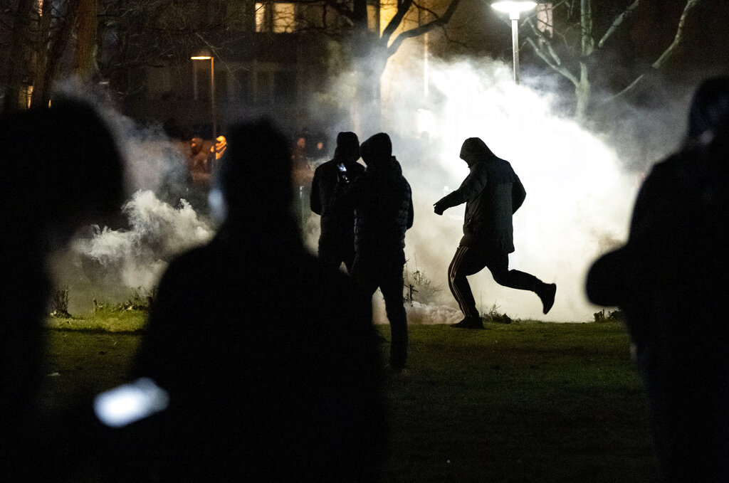 People are silhouetted by smoke after protests broke out at Rosengard in Malmo, Sweden, early Monday, April 17, 2022. The riots broke out following Danish far-right politician Rasmus Paludan’s meetings and planned Quran burnings in various Swedish cities and towns since Thursday. (Johan Nilsson/TT via AP)