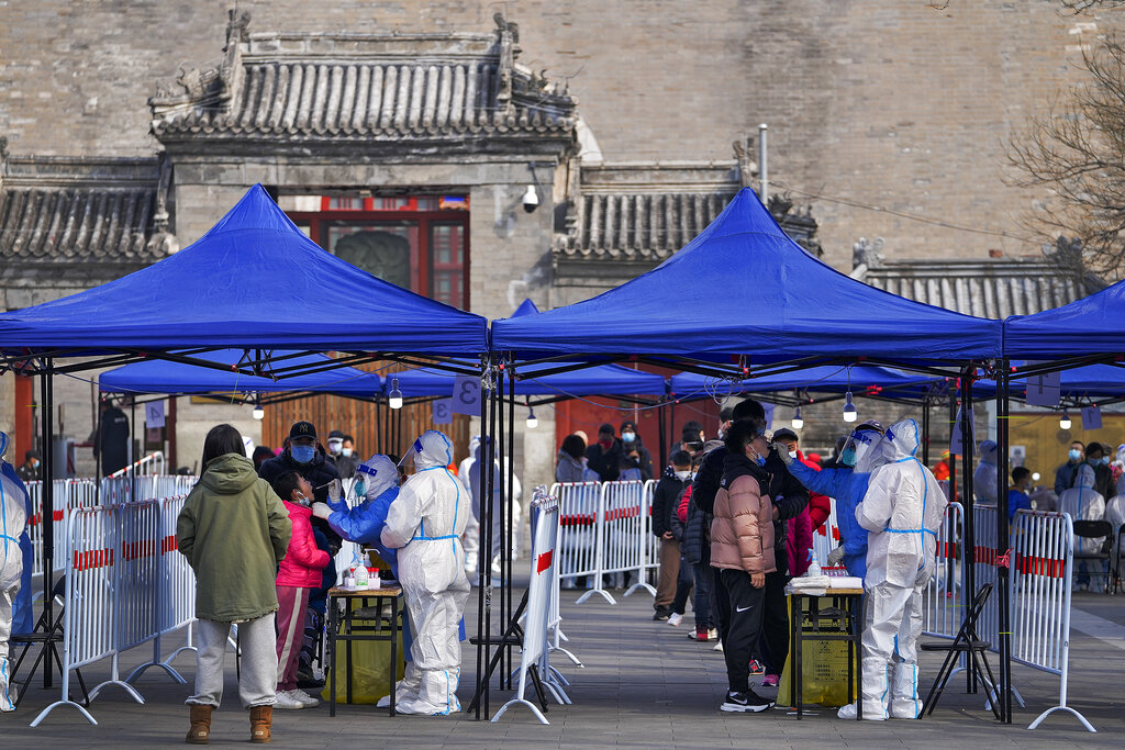 Residents line up to get a coronavirus test at an outdoor testing site setup outside the Drum Tower, Wednesday, March 23, 2022, in Beijing, China. A fast-spreading variant known as 