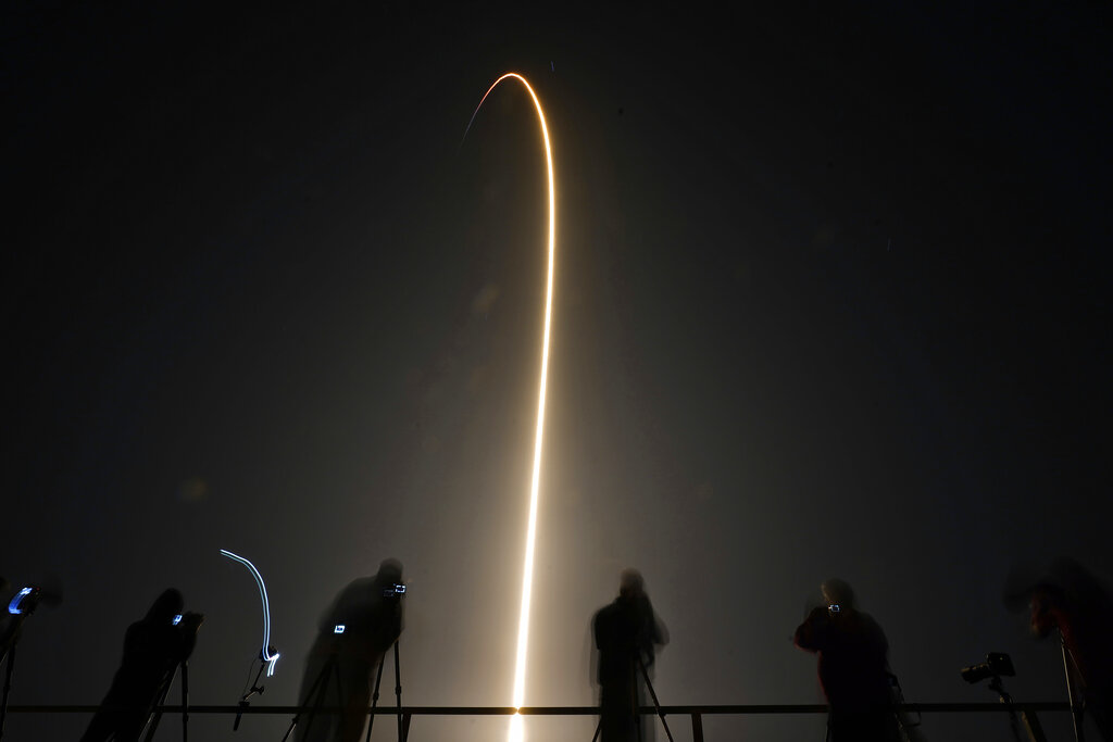 Photographers record a SpaceX Falcon 9 rocket as it lifts off in this time exposure from Launch Complex 39-A Wednesday, April 27, 2022, at the Kennedy Space Center in Cape Canaveral, Fla. Four astronauts will fly on SpaceX's Crew-4 mission to the International Space Station. (AP Photo/Chris O'Meara)