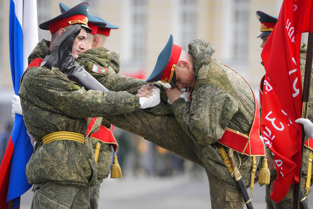 Honour guard soldiers warm up prior to a rehearsal for the Victory Day military parade which will take place at Dvortsovaya (Palace) Square on May 9 to celebrate 77 years after the victory in World War II in St. Petersburg, Russia, Tuesday, April 26, 2022. (AP Photo/Dmitri Lovetsky)