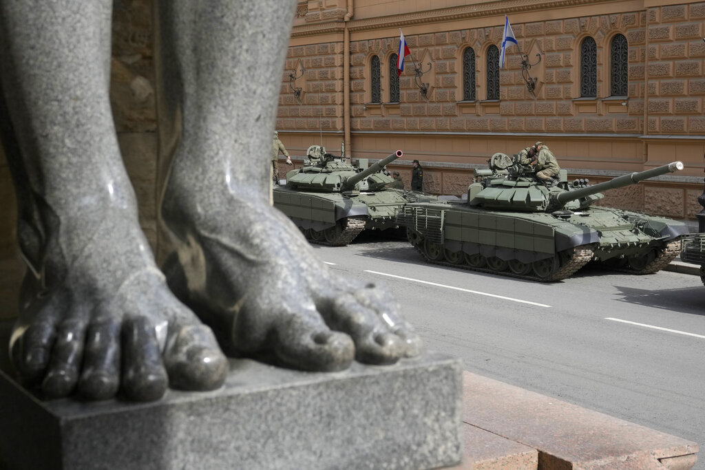 Soldiers prepare their Russian T-72 tanks prior to a rehearsal for the Victory Day military parade which will take place at Dvortsovaya (Palace) Square on May 9 to celebrate 77 years after the victory in World War II in St. Petersburg, Russia, Thursday, April 28, 2022, with feet of a famous sculpture of Atlas at the State Hermitage museum in the foreground. (AP Photo/Dmitri Lovetsky)