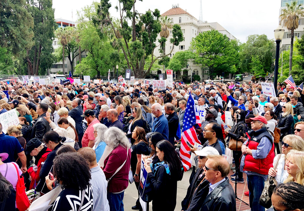 Hundreds of people bow their heads in prayer at a rally outside the state Capitol in Sacramento, Calif., on Tuesday, April 19, 2022. Protesters opposed a bill in the state Legislature that seeks to strengthen state laws preventing prosecution of women for the death of an unborn (AP Photo/Adam Beam)