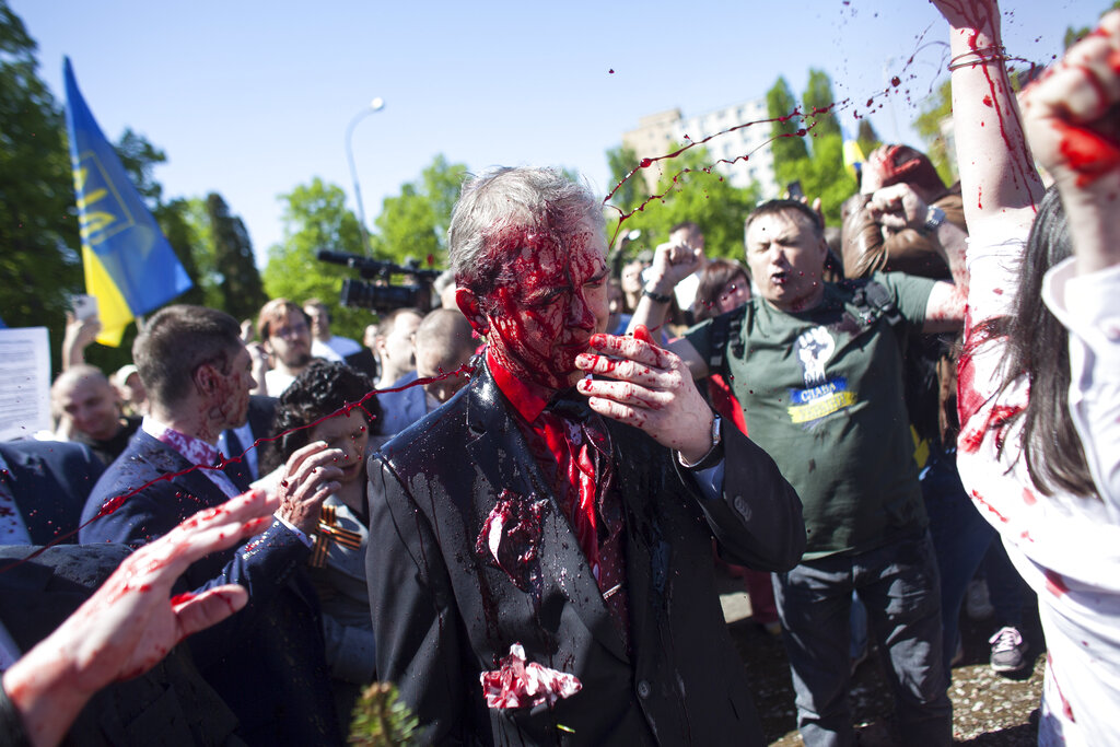 Russian Ambassador to Poland, Ambassador Sergey Andreev is covered with red paint in Warsaw, Poland, Monday, May 9, 2022. Protesters have thrown red paint on the Russian ambassador as he arrived at a cemetery in Warsaw to pay respects to Red Army soldiers who died during World War II. Ambassador Sergey Andreev arrived at the Soviet soldiers cemetery on Monday to lay flowers where a group of activists opposed to Russia’s war in Ukraine were waiting for him. (AP Photo/Maciek Luczniewski)