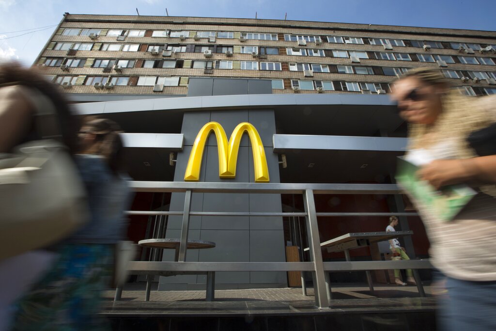 People walk past the oldest of Moscow's McDonald's outlets which was opened on Jan. 31, 1990, and closed on Thursday, Aug. 21, 2014. Russian news agencies reported Thursday that the country's food safety agency will conduct checks on McDonald's restaurants in the Urals following food safety complaints, a day after four branches of the chain were shuttered in Moscow. (AP Photo/Alexander Zemlianichenko)