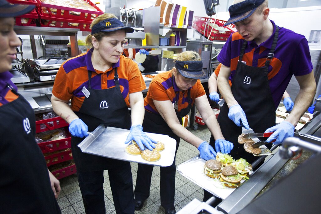 Employees cook burgers in the McDonald's restaurant situated at the Pushkinskaya square in Moscow, Russia, Thursday, April 11, 2013. This is the first McDonald's restaurant in Russia, opened at January 31, 1990. (AP Photo/Pavel Golovkin)