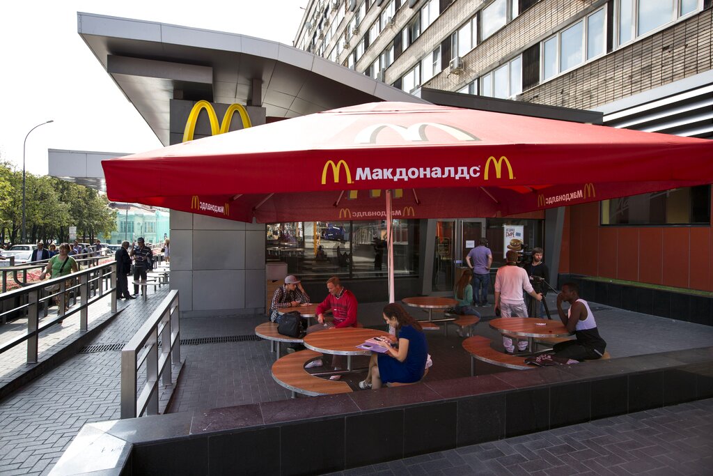 People walk past the oldest Moscow's McDonald's outlet in downtown Moscow, which was opened on Jan. 31, 1990, and is closed on Thursday, Aug. 21, 2014. Russian news agencies reported Thursday that the country's food safety agency will conduct checks on McDonald's restaurants in the Urals following food safety complaints, a day after four branches of the chain were shuttered in Moscow. (AP Photo/Alexander Zemlianichenko)