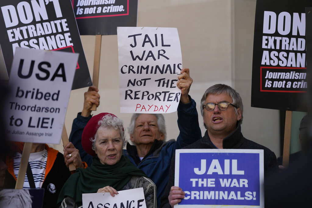 Wikileaks founder Julian Assange supporters hold placards as they gather outside Westminster Magistrates court In London, Wednesday, April 20, 2022. The court is expected to issue an extradition order to send Assange to the United States, which will then be sent to the Home Secretary Priti Patel for approval. Assange's defence will then make submissions to Patel by May 18th, in an attempt to stay the order. (AP Photo/Alastair Grant)