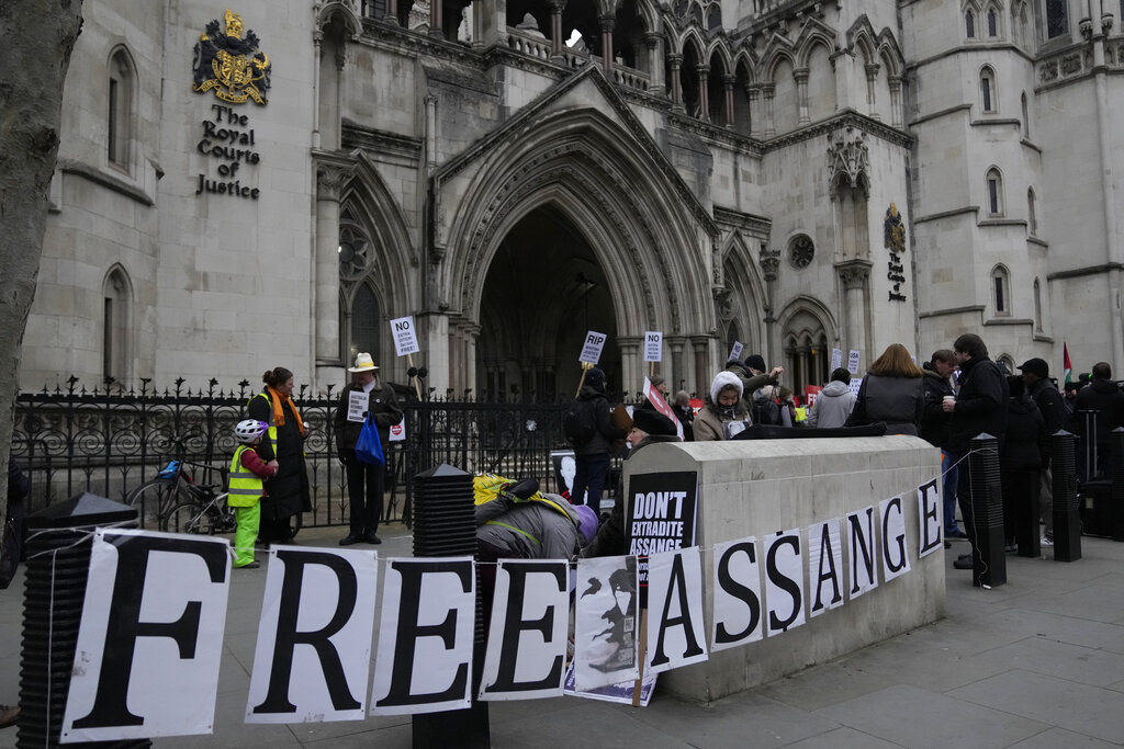 Supporters of Julian Assange stand outside the High Court, in London, Monday, Jan. 24, 2022. WikiLeaks founder Julian Assange has won the first stage of his effort to appeal a U.K. ruling that opened the door for his extradition to U.S. to stand trial on espionage charges. The High Court in London gave Assange permission appeal the case to the U.K. Supreme Court. (AP Photo/Alastair Grant)