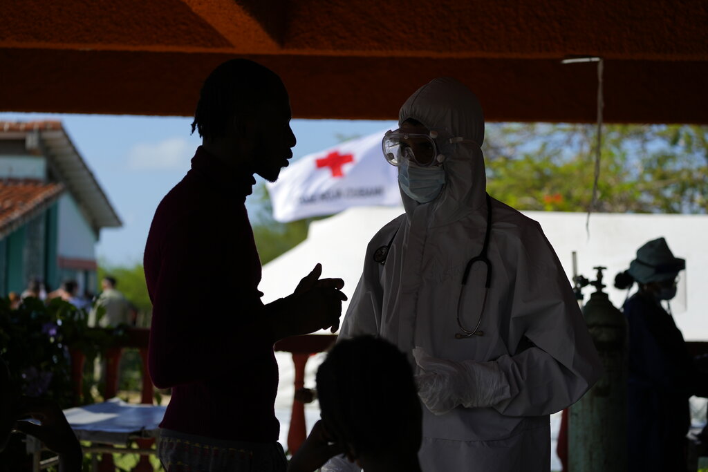 A Haitian migrant speaks with a healthcare worker at a tourist campground in Sierra Morena, in the Villa Clara province of Cuba, Wednesday, May 25, 2022. A vessel carrying more than 800 Haitians trying to reach the United States wound up instead on the coast of central Cuba, government news media said Wednesday. (AP Photo Ramon Espinosa)