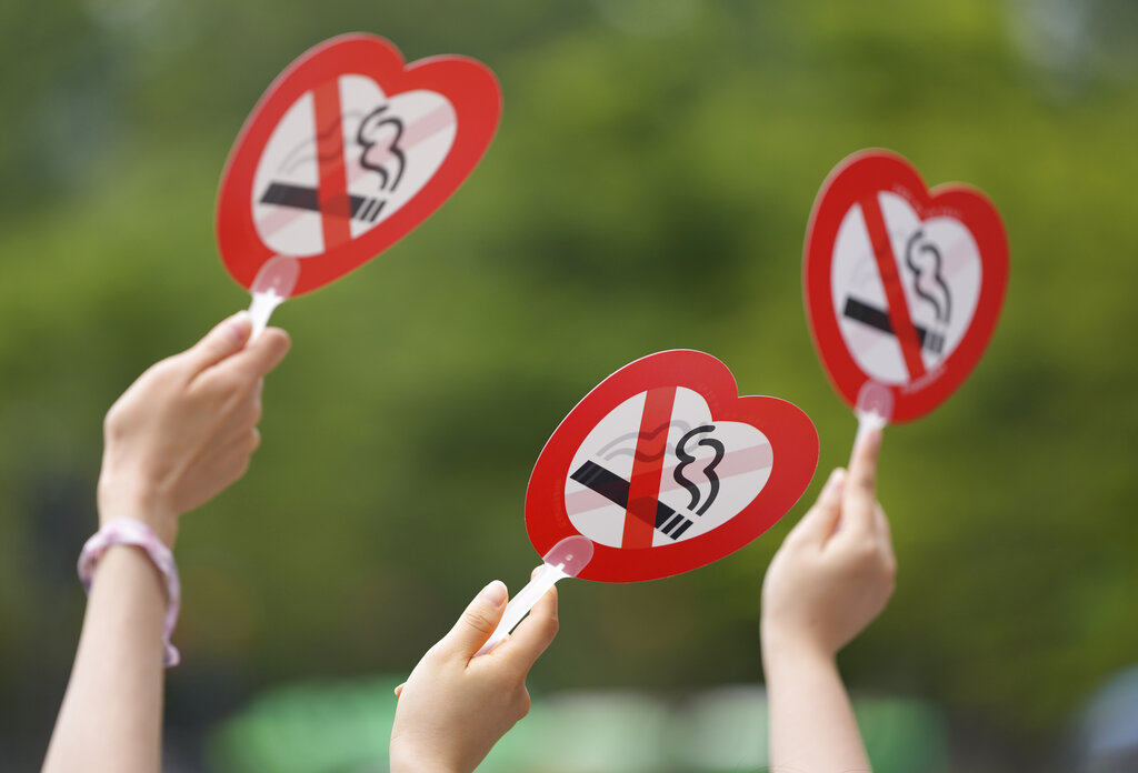 Activists hold no-smoking signs during a campaign on a street to mark World No Tobacco Day in Seoul, South Korea, Monday, May 31, 2021. (AP Photo/Lee Jin-man)