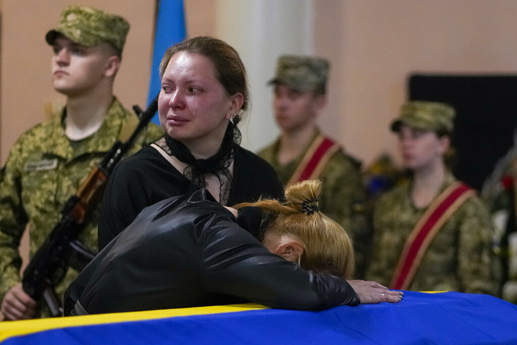 Relatives mourn during a funeral service for Army Col. Oleksander Makhachek in Zhytomyr, Ukraine, Friday, June 3, 2022. According to combat comrades Makhachek was killed fighting Russian forces when a shell landed in his position on May 30. (AP Photo/Natacha Pisarenko)