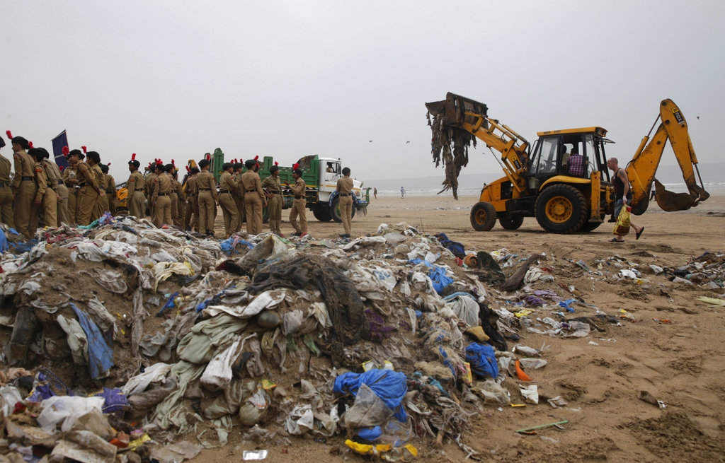 An earthmover clears garbage from the shores of the Arabian Sea in Mumbai, India, Tuesday, June 5, 2018. The U.N. says government bans on plastic can be effective in cutting back on waste but poor planning and follow-through have left many such bans ineffective. (AP Photo/Rafiq Maqbool)