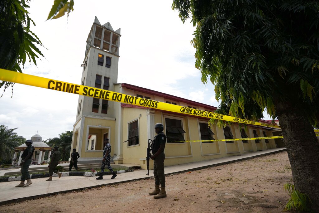 Nigerian police stand guard outside of the St. Francis Catholic church in Owo, Nigeria, Monday, June 6, 2022 a day after an attack that targeted worshipers. The gunmen who killed 50 people at a Catholic church in southwestern Nigeria opened fire on worshippers both inside and outside the building in a coordinated attack before escaping the scene, authorities and witnesses said Monday. (AP Photo/Sunday Alamba)