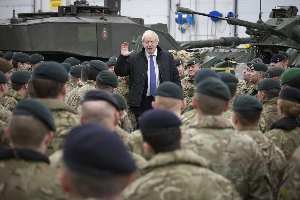 Britain's Prime Minister Boris Johnson addresses British soldiers after serving Christmas lunch to British troops stationed in Estonia during a one-day visit to the Baltic country, in Tallinn, Saturday, Dec. 21, 2019. (Stefan Rousseau/Pool photo via AP)