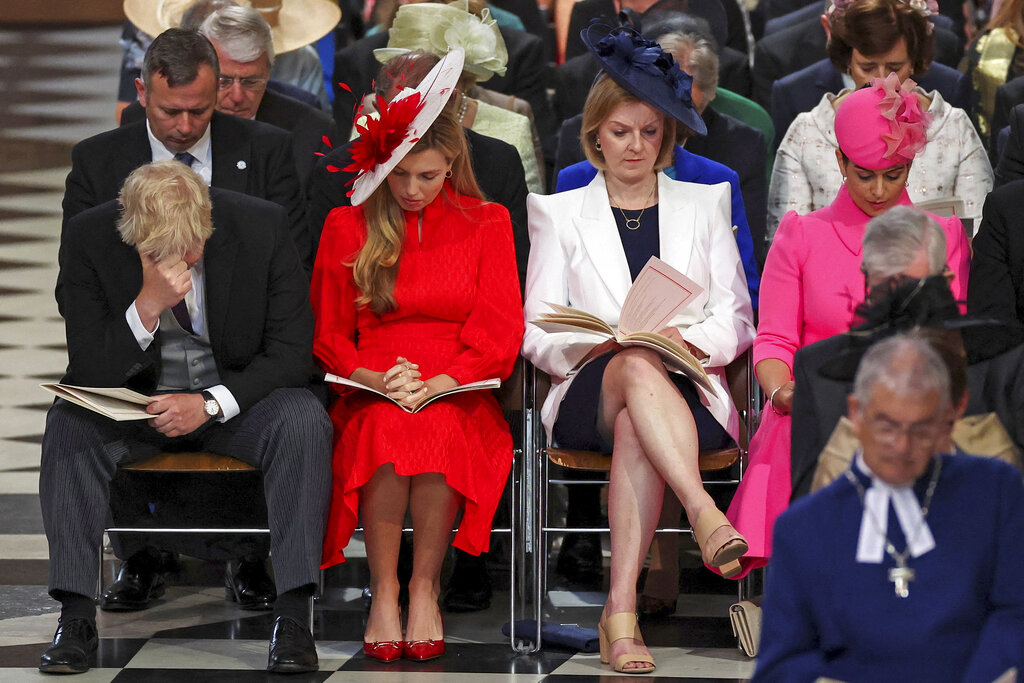 FILE - British Prime Minister Boris Johnson, right, reacts as he sits next to his wife Carrie Johnson, British Foreign Secretary Liz Truss and Home Secretary Priti Patel, right, at the National Service of Thanksgiving held at St Paul's Cathedral as part of celebrations marking the Platinum Jubilee of Britain's Queen Elizabeth II, in London, Friday, June 3, 2022. Britain's governing Conservatives will hold a no-confidence vote in Prime Minister Boris Johnson on Monday, June 6, 2022 that could oust him as Britain's leader. (Phil Noble/Pool photo via AP, File)
