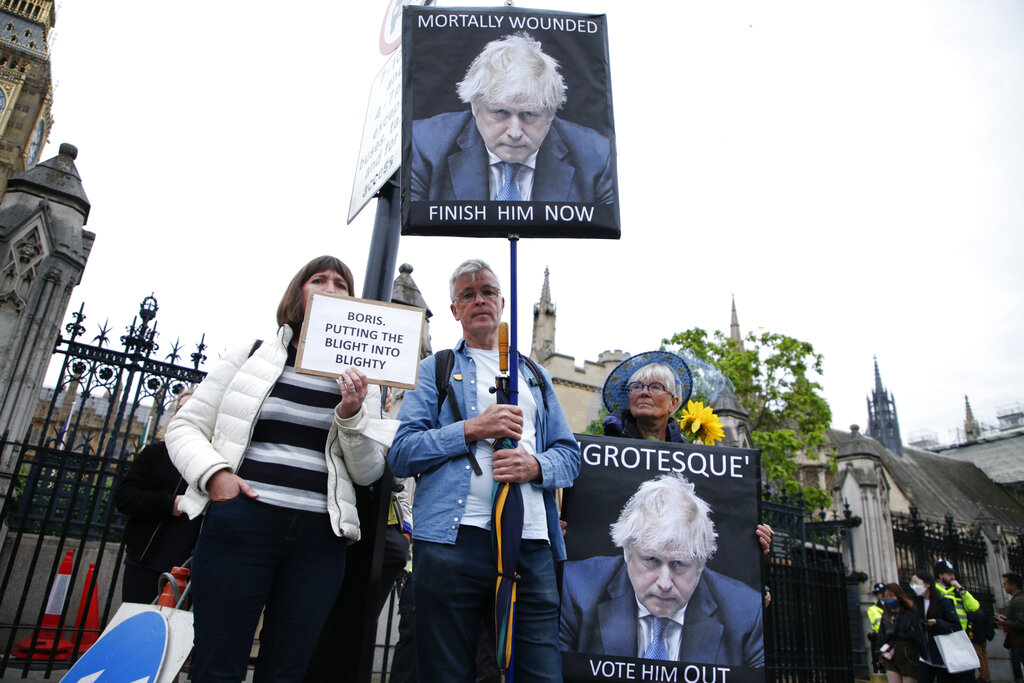 Protesters calling for the removal of British Prime Minister Boris Johnson, demonstrate outside the Houses of Parliament in London, Monday, June 6, 2022. Johnson faces a no-confidence vote Monday that could oust him from power, as discontent with his rule finally threatens to topple a politician who has often seemed invincible despite many scandals. (AP Photo/David Cliff)