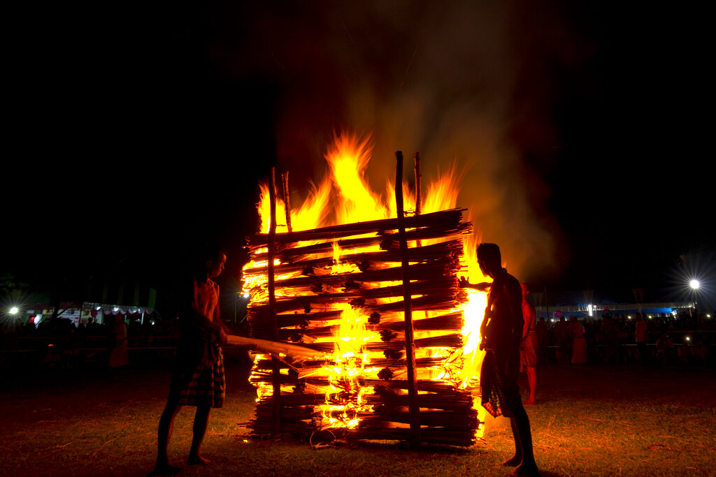 Indian Rabha tribal Hindu priests burn wood during Baikho festival at Gamerimura village along the Assam Meghalaya border, west of Gauhati, India, Saturday, June 4, 2022. Every year, the community in India's northeastern state of Assam celebrates the festival, to please a deity of wealth and ask for good rains and a good harvest. (AP Photo/Anupam Nath)