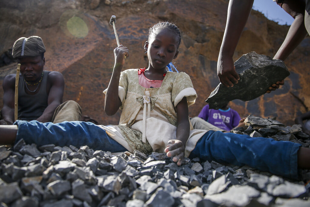 Irene Wanzila, 10, breaks rocks with a hammer at the Kayole quarry in Nairobi, Kenya Tuesday, Sept. 29, 2020, as she works along with her younger brother, older sister and mother, who says she was left without a choice after she lost her cleaning job at a private school when coronavirus pandemic restrictions were imposed. The United Nations says the COVID-19 pandemic risks significantly reducing gains made in the fight against child labor, putting millions of children at risk of being forced into exploitative and hazardous jobs, and school closures could exacerbate the problem. (AP Photo/Brian Inganga)