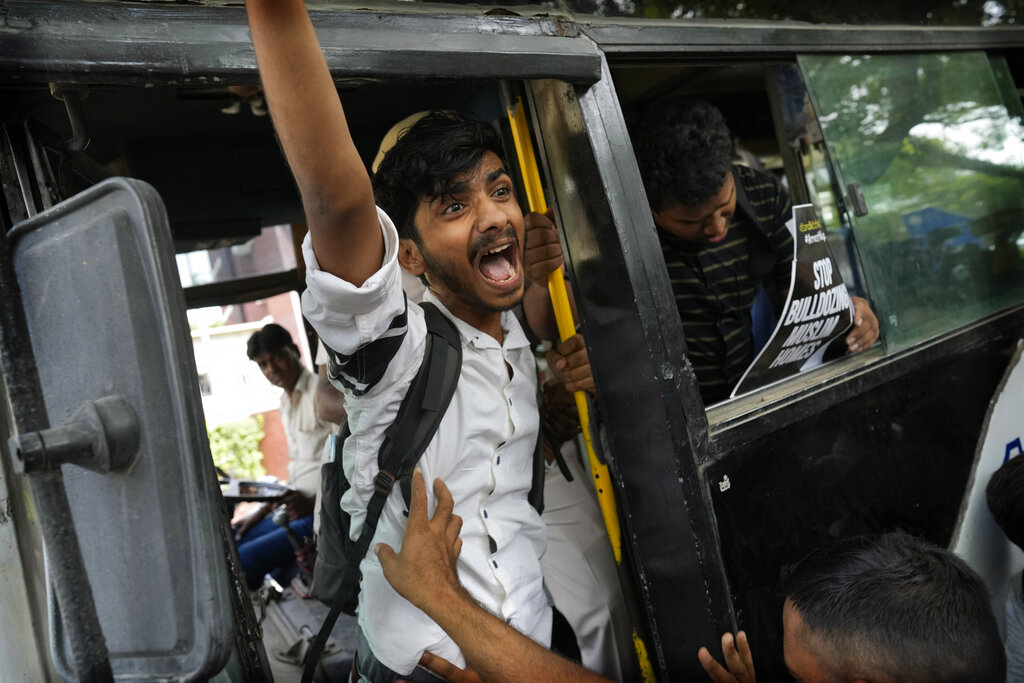 A Muslim student is detained during a protest outside Uttar Pradesh house, in New Delhi, Monday, June 13, 2022. The students were protesting against persecution of Muslims and recent demolition of their houses following last week's protests against former Bharatiya Janata Party spokesperson Nupur Sharma's remark deemed derogatory to Islam's Prophet Muhammad. (AP Photo/Manish Swarup)