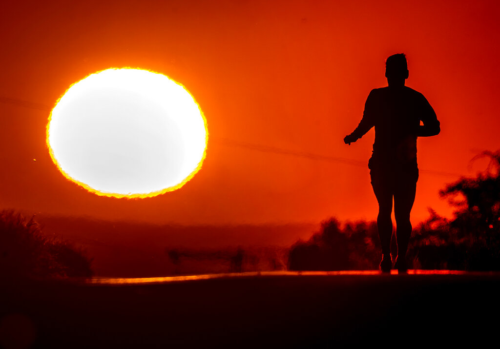 A man runs up a hill on a small road in Frankfurt, Germany, as the sun rises on Friday, June 17, 2022. A blanket of hot air stretching from the Mediterranen to the North Sea is giving much of western Europe its first heat wave of the summer, with temperatures forecast to top 86 degrees Fahrenheit from Malaga to London on Friday. Some areas are expected to see the mercury pass 104F. Germany’s national weather service DWD predicted that the big sweat would continue over the weekend, as the heat moves eastward into central and eastern Europe. (AP Photo/Michael Probst)