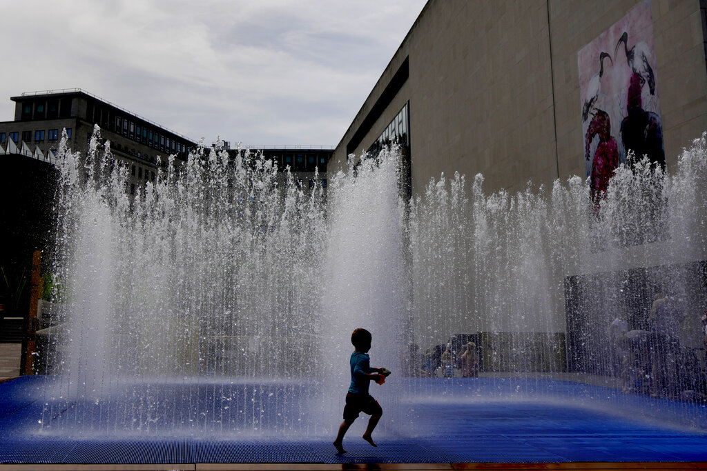 A child plays in a fountain in the warm weather in London, Friday, June 17, 2022. A blanket of hot air stretching from the Mediterranean to the North Sea is giving much of western Europe its first heat wave of the summer, with temperatures forecast to top 30 degrees Celsius (86 degrees Fahrenheit) from Malaga to London on Friday. (AP Photo/Kirsty Wigglesworth)