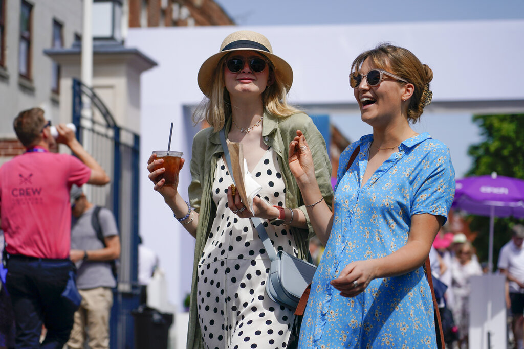 Spectators hold drinks as they enter the Queen's Club Championships, in London, Friday, June 17, 2022. A blanket of hot air stretching from the Mediterranean to the North Sea is giving much of western Europe its first heat wave of the summer, with temperatures forecast to top 30 degrees Celsius (86 degrees Fahrenheit) from Malaga to London on Friday. (AP Photo/Alberto Pezzali)