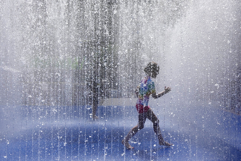 A child plays in a fountain in the warm weather in London, Friday, June 17, 2022. A blanket of hot air stretching from the Mediterranean to the North Sea is giving much of western Europe its first heat wave of the summer, with temperatures forecast to top 30 degrees Celsius (86 degrees Fahrenheit) from Malaga to London on Friday. (AP Photo/Kirsty Wigglesworth)