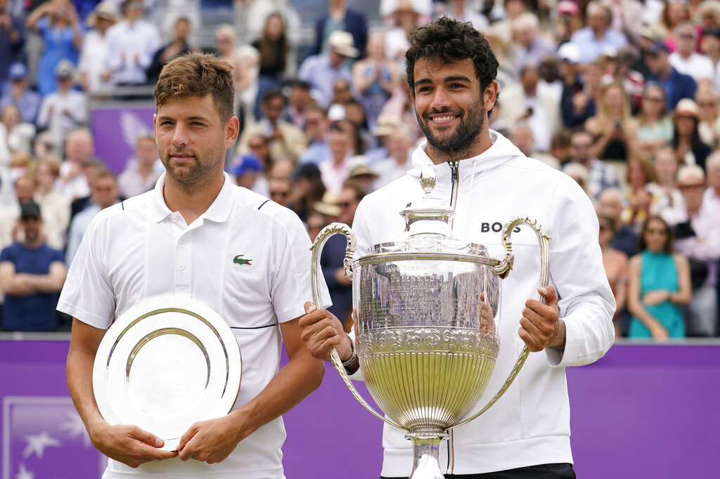 Italy's Matteo Berrettini, right, the winner and Serbia's Filip Krajinovic, left, the runner-up hold their trophies after the final tennis match at the Queen's Club Championships in London, Sunday, June 19, 2022. (AP Photo/Alberto Pezzali)