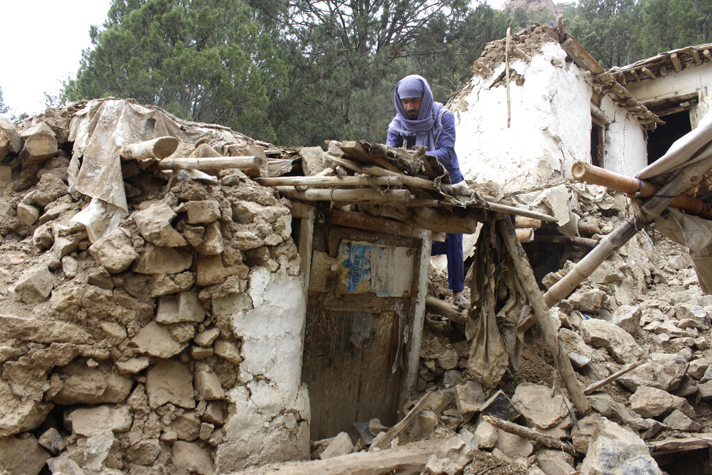 An Afghan villager collects his belongings from under the rubble of his home that was destroyed in an earthquake in the Spera District of the southwestern part of Khost Province, Afghanistan, Wednesday, June 22, 2022. A powerful earthquake struck a rugged, mountainous region of eastern Afghanistan early Wednesday, killing at least 1,000 people and injuring 1,500 more in one of the country's deadliest quakes in decades, the state-run news agency reported. (AP Photo)