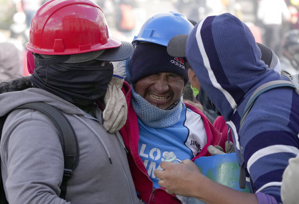 An injured demonstrator is helped by his comrades during clashes with the police as protests raged against President Guillermo Lasso's economic policies and demanding a fuel price cut, in downtown Quito, Ecuador, Thursday, June 23, 2022. (AP Photo/Dolores Ochoa)