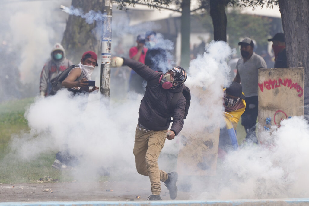 A demonstrator hurls a tear gas canister back at police during protests against the government of President Guillermo Lasso and rising fuel prices in Quito, Ecuador, Tuesday, June 21, 2022. Ecuador's defense minister warned Tuesday that the country's democracy was at risk as demonstrations turned increasingly violent in the capital. (AP Photo/Dolores Ochoa)