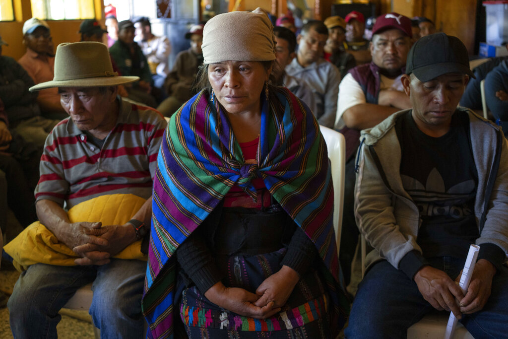 Magdalena Tepaz, center, and Manuel de Jesus Tulul, right, parents of Wilmer Tulul, wait for the start of a community meeting in Tzucubal, Guatemala, Wednesday, June 29, 2022.  Wilmer and his cousin Pascual, both 13, were among the dead discovered inside a tractor-trailer near auto salvage yards on the edge of San Antonio, Texas, on Monday, in what is believed to be the nation's deadliest smuggling episode on the U.S.-Mexico border. (AP Photo/Moises Castillo)