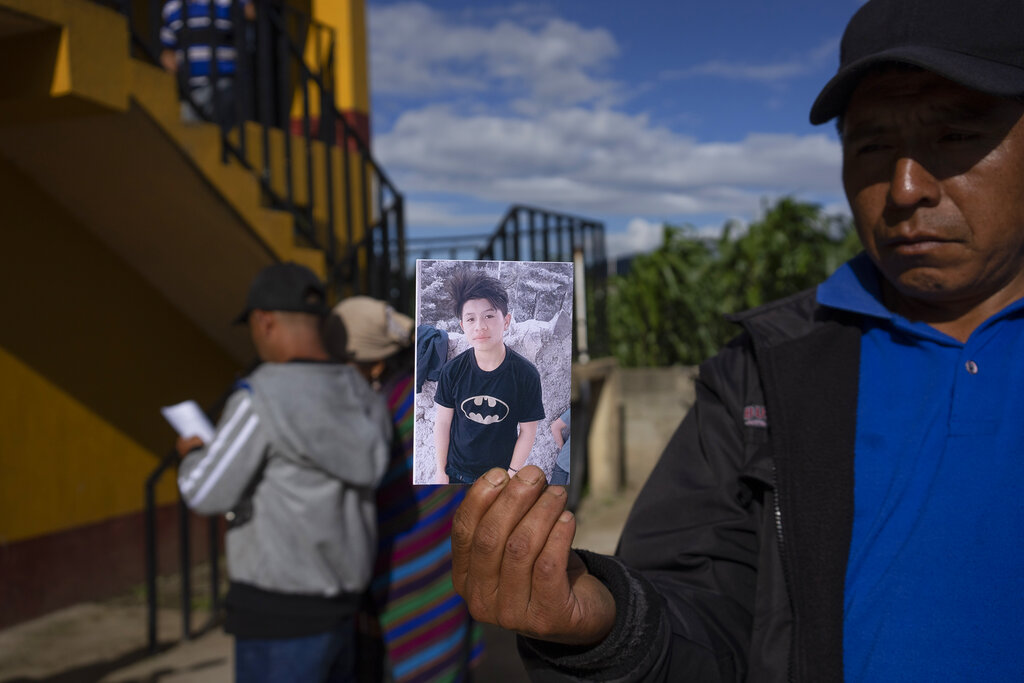 A man shows a portrait of Wilmer Tulul, in Tzucubal, Guatemala, Wednesday, June 29, 2022. Wilmer and his cousin Pascual, both 13, were among the dead discovered inside a tractor-trailer near auto salvage yards on the edge of San Antonio, Texas, on Monday, in what is believed to be the nation's deadliest smuggling episode on the U.S.-Mexico border. (AP Photo/Moises Castillo)