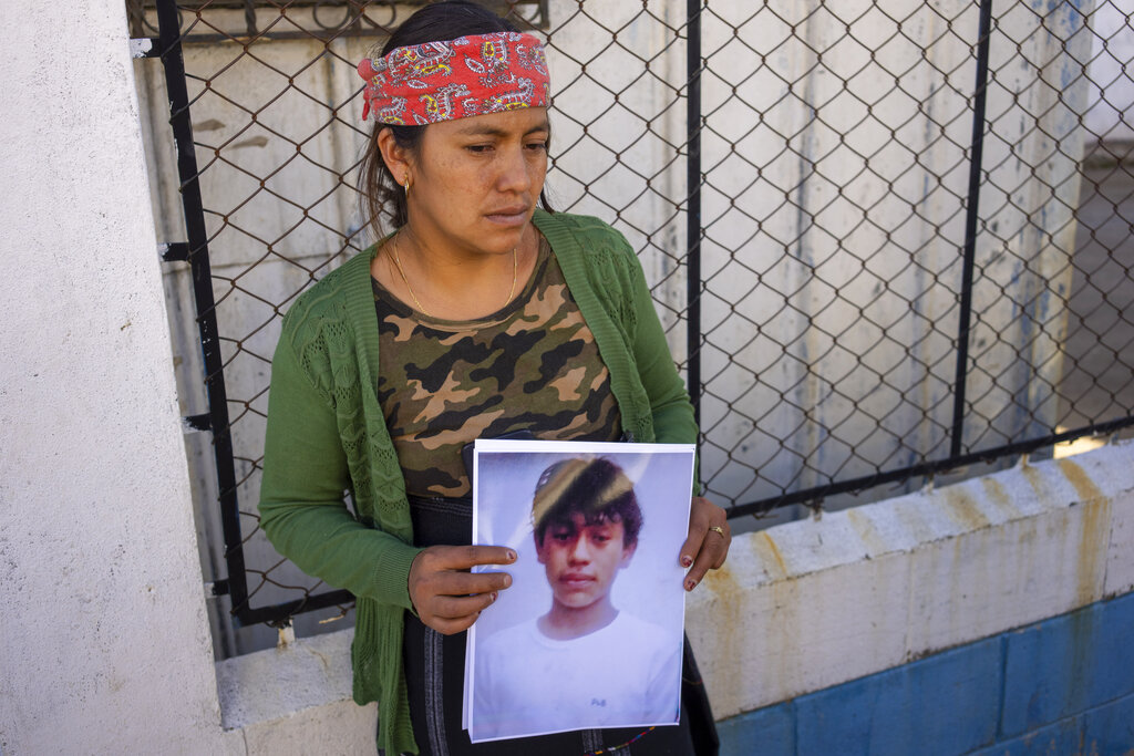 Maria Sipac Coj holds a portrait of her son Pascual Melvin Guachiac in Tzucubal, Guatemala, Wednesday, June 29, 2022. Pascual and his cousin Wilmer Tulul, both 13, were among the dead discovered inside a tractor-trailer near auto salvage yards on the edge of San Antonio, Texas, on Monday, in what is believed to be the nation's deadliest smuggling episode on the U.S.-Mexico border. (AP Photo/Moises Castillo)