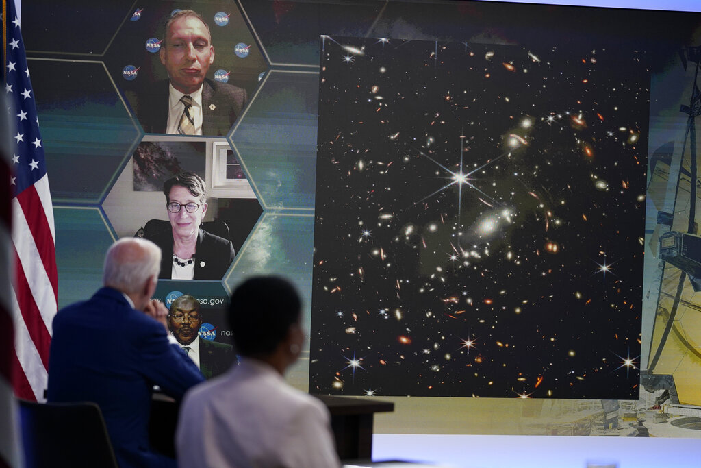 President Joe Biden listens during a briefing from NASA officials about the first images from the Webb Space Telescope, the highest-resolution images of the infrared universe ever captured, in the South Court Auditorium on the White House complex, Monday, July 11, 2022, in Washington. On screen are NASA Associate Administrator for the Science Mission Directorate Thomas Zurbuchen, top, Deputy Director of the Space Telescope Science Institute (STScI) Nancy Levenson, and NASA James Webb Space Telescope Program Director Greg Robinson, bottom.  (AP Photo/Evan Vucci)