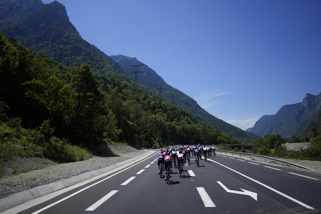 The pack leaves the French Alps during the thirteenth stage of the Tour de France cycling race over 193 kilometers (119.9 miles) with start in Le Bourg d'Oisans and finish in Saint-Etienne, France, Friday, July 15, 2022. (AP Photo/Thibault Camus)