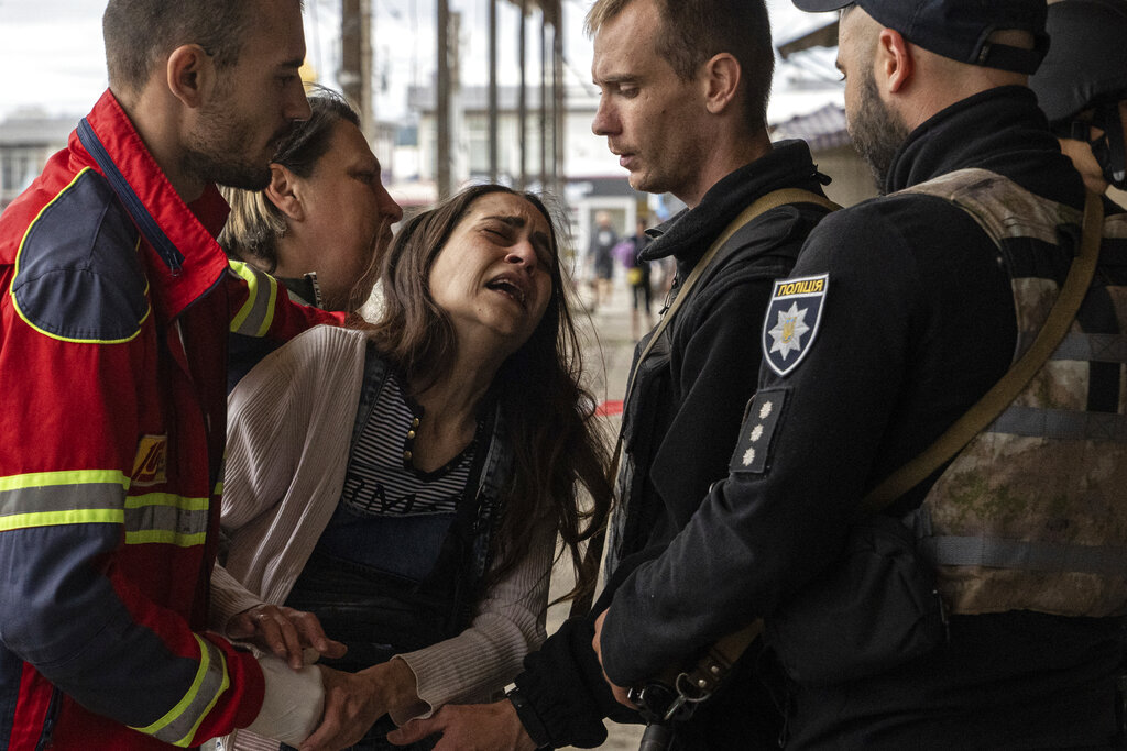 Sabina, centre, cries after her husband Artem Pogorelets was killed by Russian shelling at Barabashovo market in Kharkiv, Ukraine, Thursday, July 21, 2022. (AP Photo/Evgeniy Maloletka)