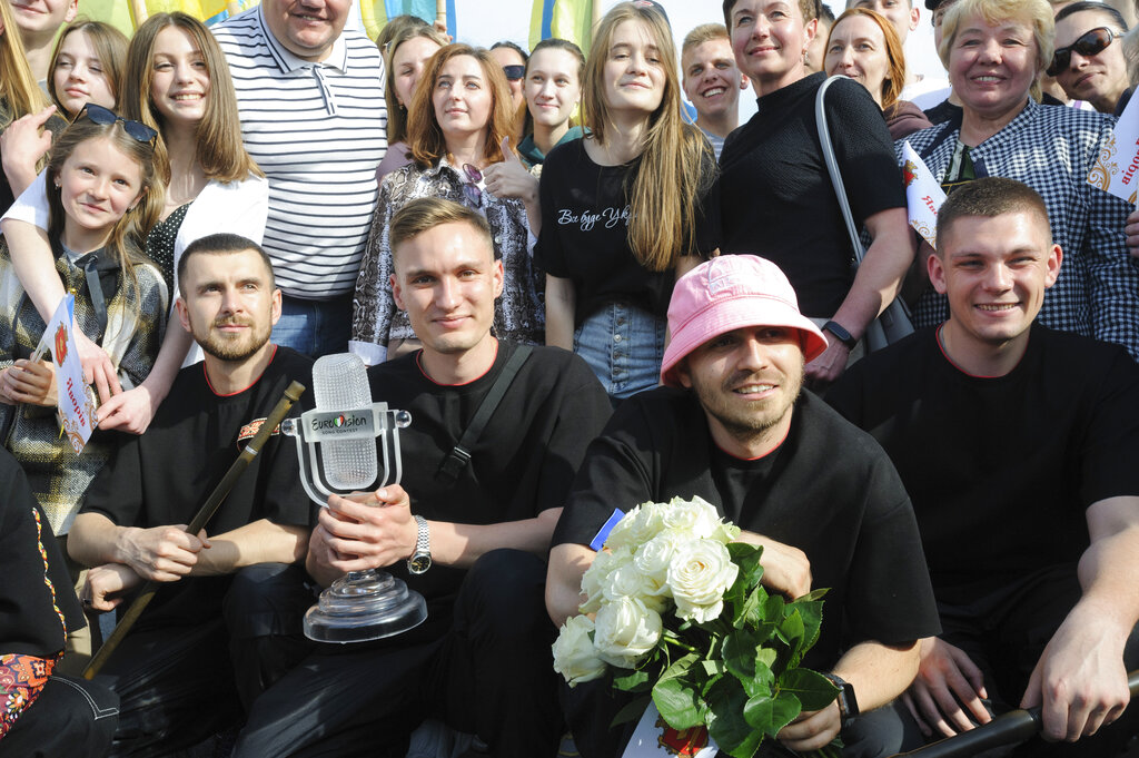 Oleh Psiuk, second from right, frontman of Ukraine's Kalush Orchestra, winners of the Eurovision Song Contest, and his band pose with the trophy in Krakovets, at the Ukraine border with Poland, Monday, May 16, 2022. (AP Photo/Mykola Tys)