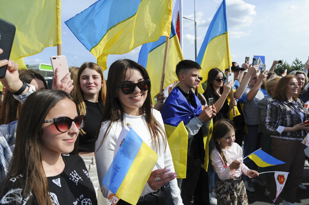 Fans wave Ukrainian flags as Ukraine's Kalush Orchestra, winners of the Eurovision Song Contest, arrive in Krakovets, at the Ukraine border with Poland, Monday, May 16, 2022. (AP Photo/Mykola Tys)