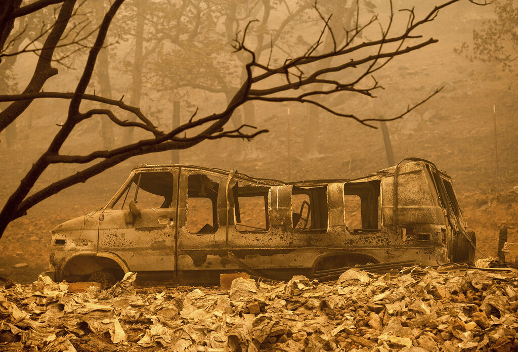 A scorched van sits in a clearing as the McKinney Fire burns in Klamath National Forest, Calif., on Sunday, July 31, 2022. (AP Photo/Noah Berger)