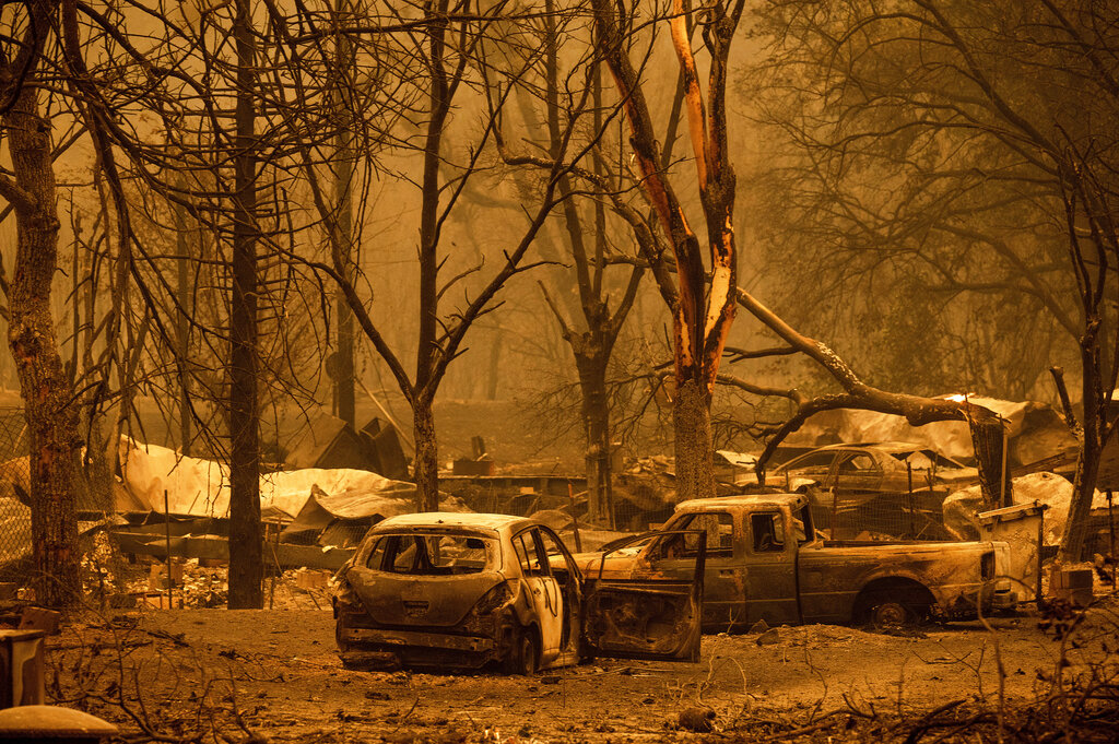 Scorched vehicles and residences line the Oaks Mobile Home Park in the Klamath River community as the McKinney Fire burns in Klamath National Forest, Calif., Saturday, July 30, 2022. (AP Photo/Noah Berger)