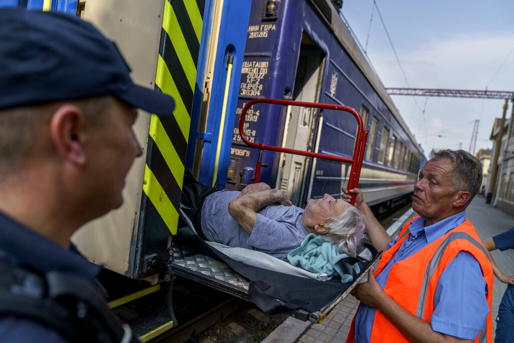 Viktor Mariukha, 84, is lifted onto an evacuation train in Pokrovsk, Donetsk region, eastern Ukraine, Tuesday, Aug. 2, 2022. The government issued an order to residents to leave the Donetsk region in the face of the Russian offensive as they're preparing for fall and winter and fear that many there may not have access to heating, electricity, or even clean water. (AP Photo/David Goldman)