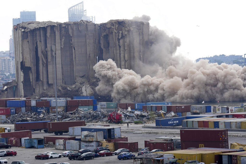 Dust rises from collapsing silos damaged during the August 2020 massive explosion in the port, in Beirut, Lebanon, Thursday, Aug. 4, 2022. A large section collapsed on Thursday as hundreds marched in Beirut to mark the second anniversary of the blast that killed scores. (AP Photo/Hussein Malla)