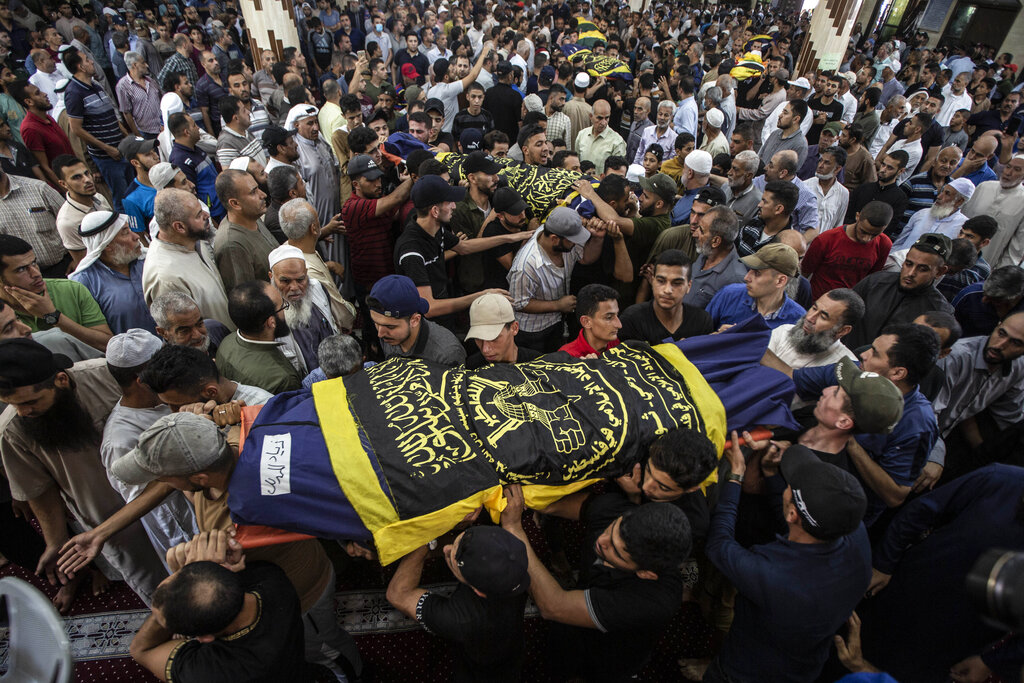 Mourners carry the bodies of Khaled Mansour a senior commander in the Palestinian militant group Islamic Jihad and other Palestinians, who were killed in Israeli airstrikes in Rafah, southern Gaza Strip, Sunday, Aug. 7, 2022, during their funeral. Israel has killed two senior Islamic Jihad militants in three days of air strikes in the Gaza Strip, and Palestinian militants have launched nearly 600 rockets at Israel. Palestinian officials say at least 31 people in Gaza have died. (AP Photo/Yousef Masoud)