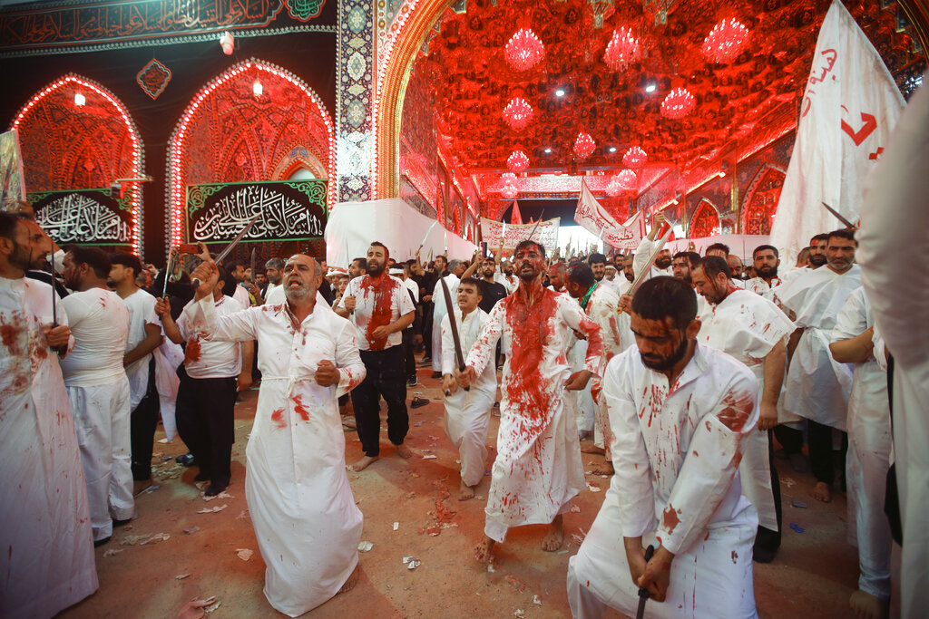 Iraqi Shiites perform self-flagellation as they attend the Ashoura ceremonies in Karbala, Iraq, Monday, Aug. 8, 2022. Ashoura marks the death of Husayn ibn Ali, a grandson of the Islamic prophet Muhammad, and members of his immediate family in the Battle of Karbala. (AP Photo/Anmar Khalil)