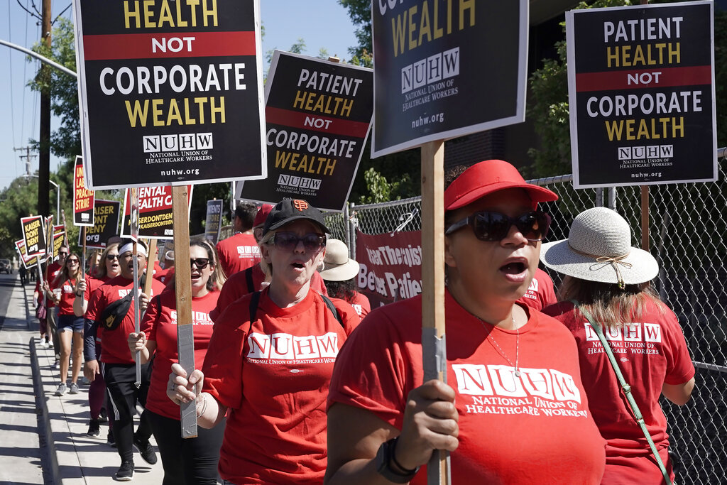 Kaiser Permanente mental health workers and supporters march outside a Kaiser facility in Sacramento, Calif., Monday, Aug. 15, 2022. More than 2,000 Kaiser Permanente psychologists, therapists and other mental health workers in Northern California started an open-ended strike Monday over high workloads and excessive wait times.(AP Photo/Rich Pedroncelli)