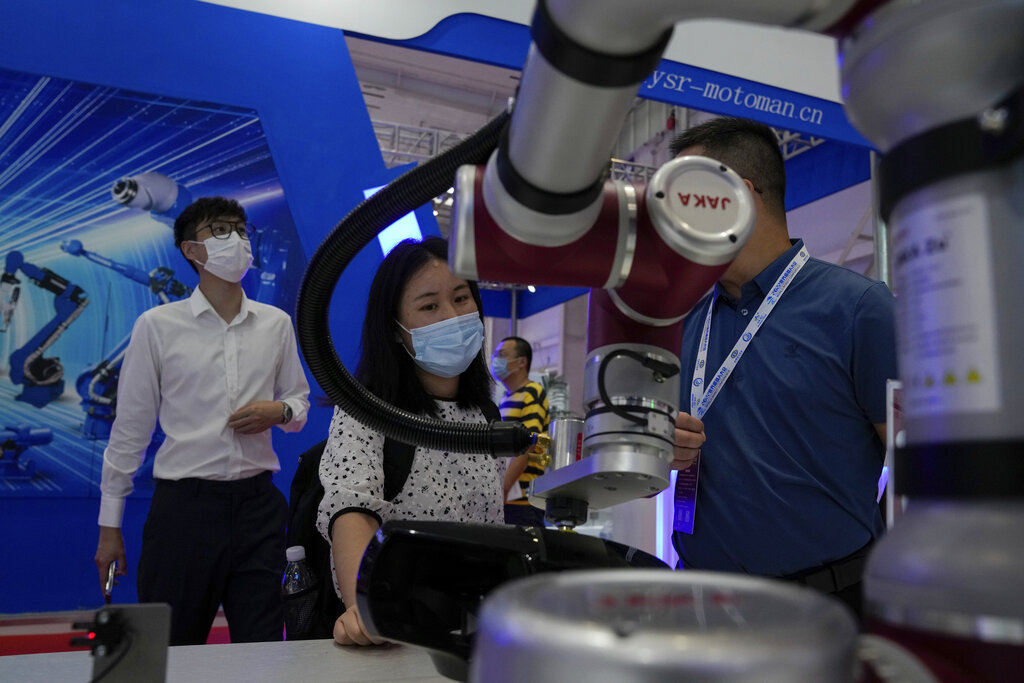 Visitors look at a Chinese-made industrial robot during the World Robot Conference at the Yichuang International Conference and Exhibition Centre in Beijing, Thursday, Aug. 18, 2022. (AP Photo/Andy Wong)