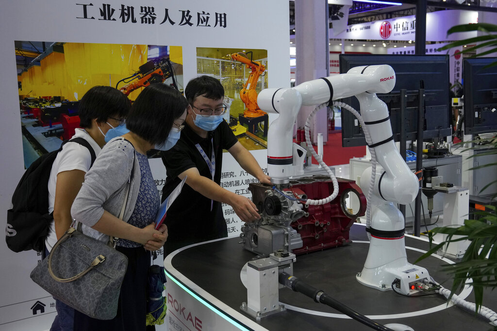 An exhibitor demonstrates a Chinese-made industrial robot to visitors at the World Robot Conference at the Yichuang International Conference and Exhibition Centre in Beijing, Thursday, Aug. 18, 2022. (AP Photo/Andy Wong)